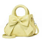 Casual women's handbags with bows in black, white, blue, and khaki PU leather, featuring trendy shoulder and underarm styles.