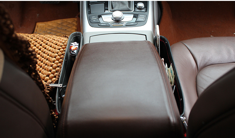 Beige car seat gap storage organizer and trash box by BACKUPMYFILESNOW.COM® sitting between car seats, holding small items and trash.