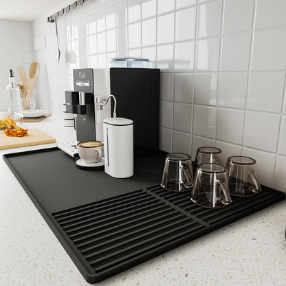 Black silicone coffee mat with raised edges, 24x16 inches, designed for countertops, coffee bars, and under espresso machines.