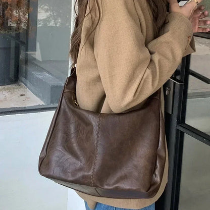 Black 2025 women's handbag with soft PU leather, foldable slouchy tote, crossbody design, vintage style with zipper closure.