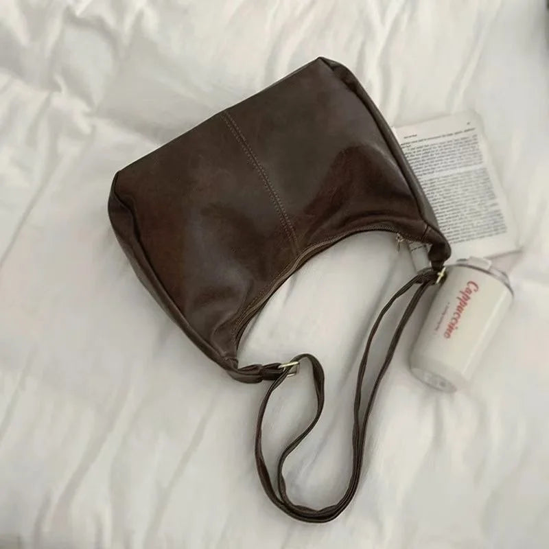 Black 2025 women’s handbag with soft PU leather, foldable slouchy tote, crossbody style, vintage design with zipper closure.