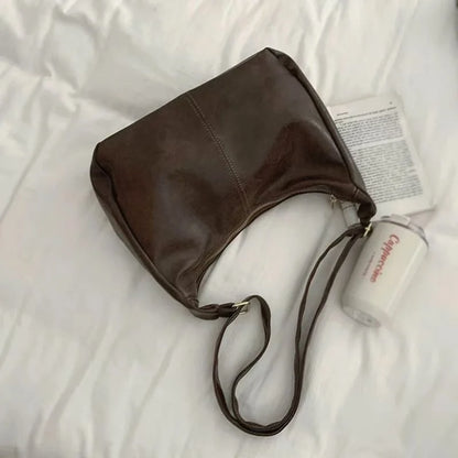 Black 2025 women’s handbag with soft PU leather, foldable slouchy tote, crossbody style, vintage design with zipper closure.