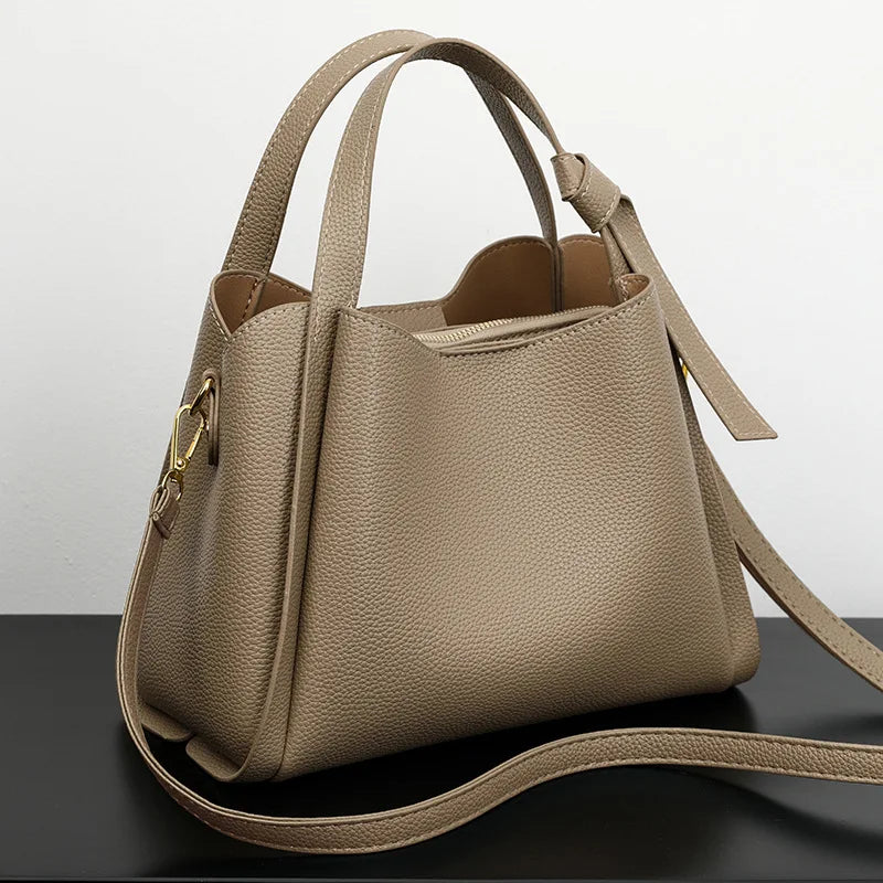 Black women's shoulder bag with retro style, simple design, textured surface, large capacity, and portable messenger bucket shape.
