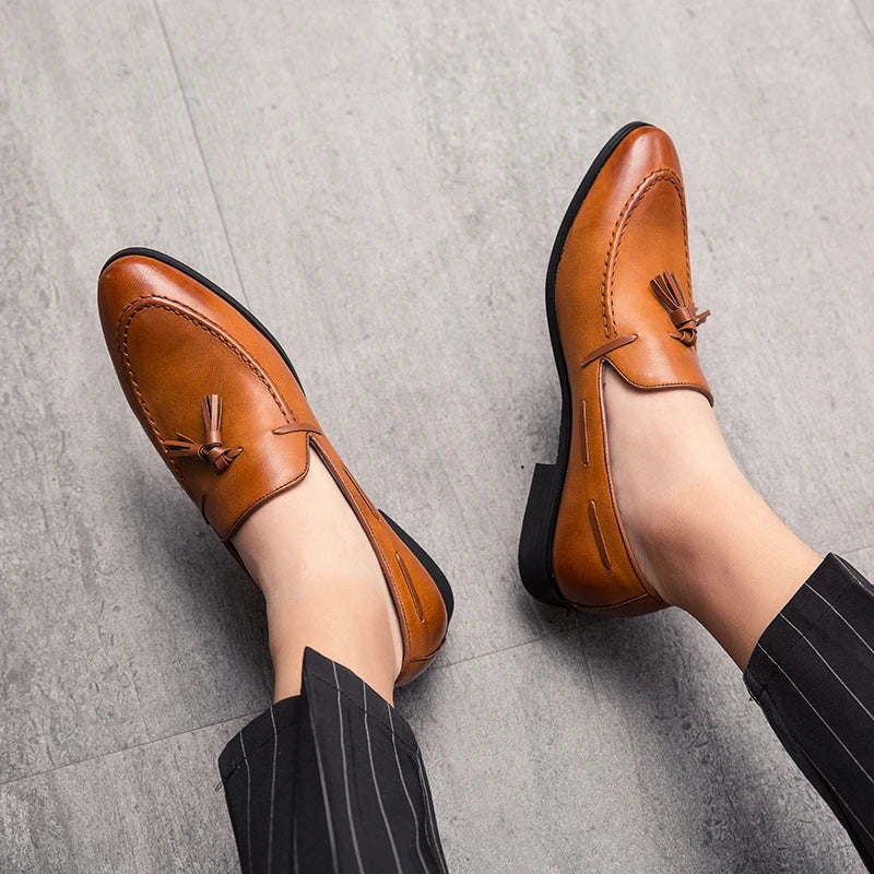 Black men's slip-on loafers with tassels, leather wedding and dress shoes in British style, suitable for formal or business occasions.