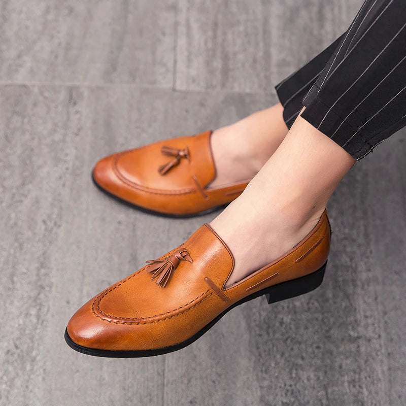Black men's slip-on loafers with tassels, leather wedding and dress shoes featuring a British formal style.