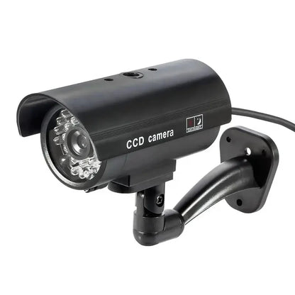 Black dummy security camera with red flashing LED light, battery-powered, suitable for indoor and outdoor use.