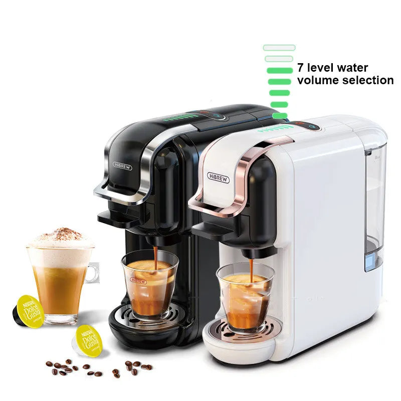 Black BACKUPMYFILESNOW.COM® espresso capsule coffee machine plugged into UK electrical outlet, modern home appliance for brewing coffee.
