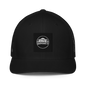 Black Flexfit 6511 closed-back trucker cap with mesh back and adjustable strap, featuring a structured front panel.
