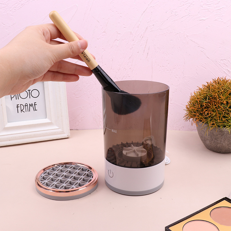 Black rechargeable makeup brush cleaner from BackupMyFilesNow.com with multiple brush slots and control panel for easy cleaning.