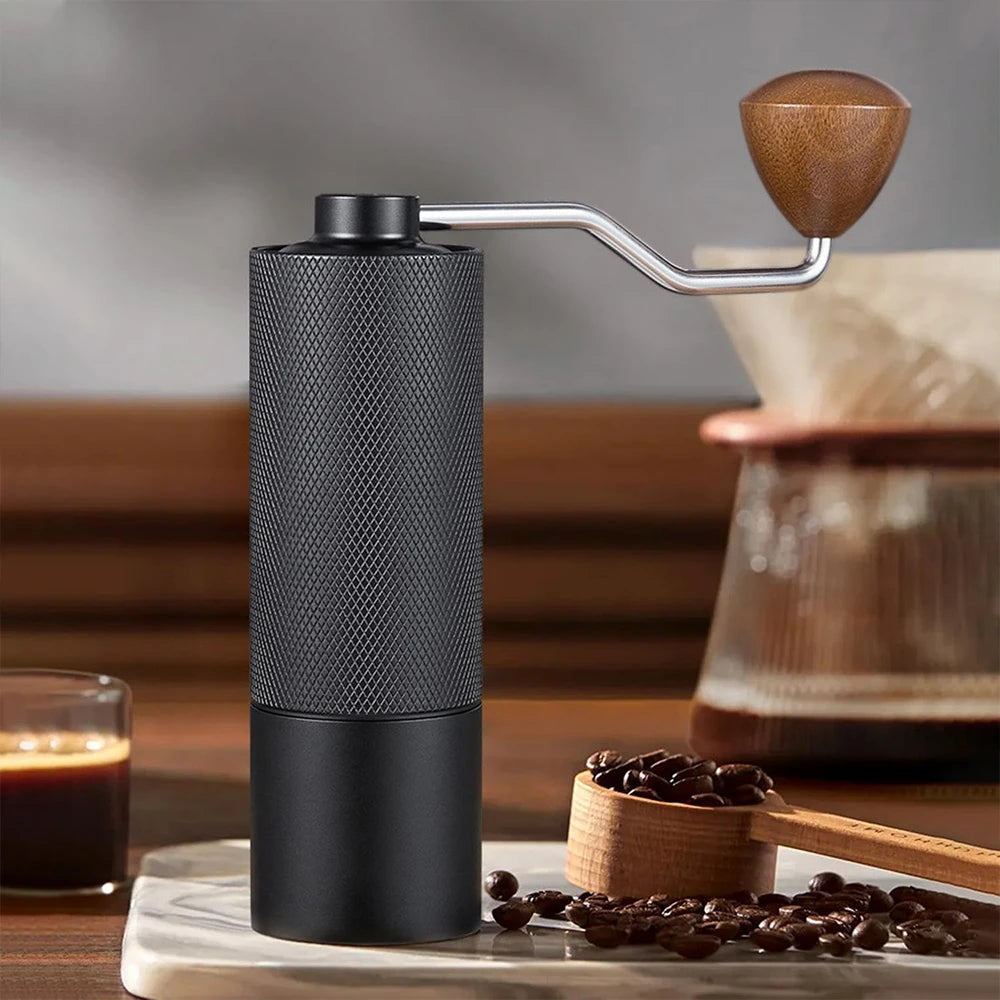 Stainless steel manual coffee grinder with conical burr, adjustable settings, portable hand design, ideal for fresh coffee brewing.