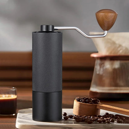 Stainless steel manual coffee grinder with conical burr, adjustable settings, portable hand design, ideal for fresh coffee brewing.
