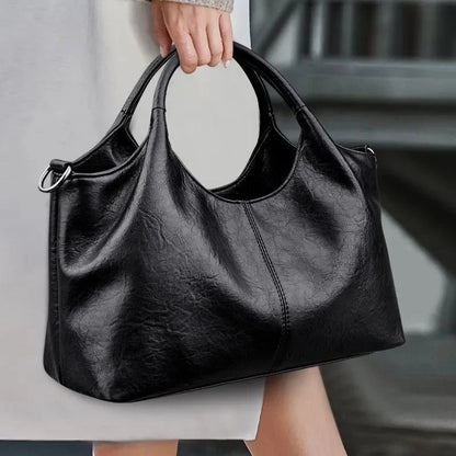 Black women's handbag with large capacity, detachable crossbody strap, handheld option, golden hardware, zipper closure, Elegant style.