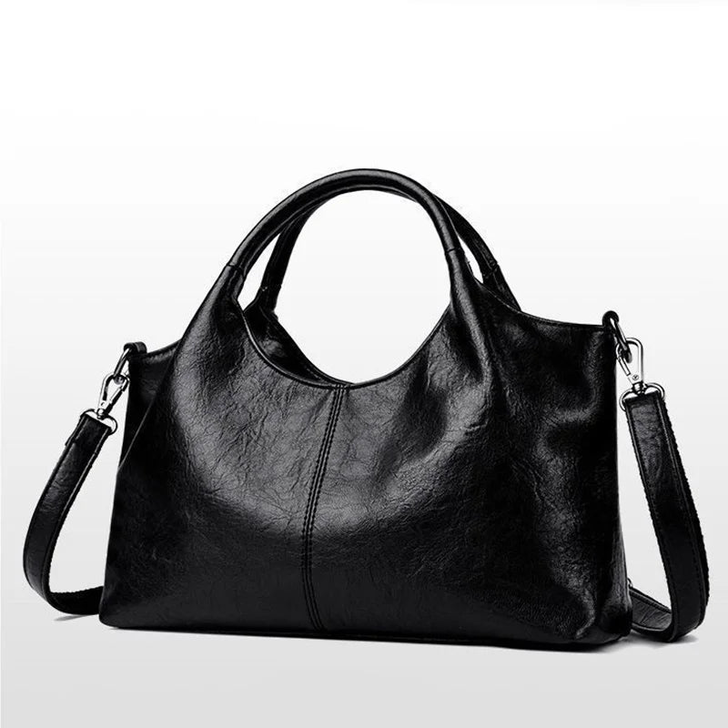 Large black women's handbag with golden hardware, detachable crossbody strap, zipper closure, elegant design, and spacious interior.
