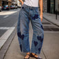 Woman wearing mid-rise barrel jeans with heart print, vintage baggy denim ankle pants, casual summer women's clothing.