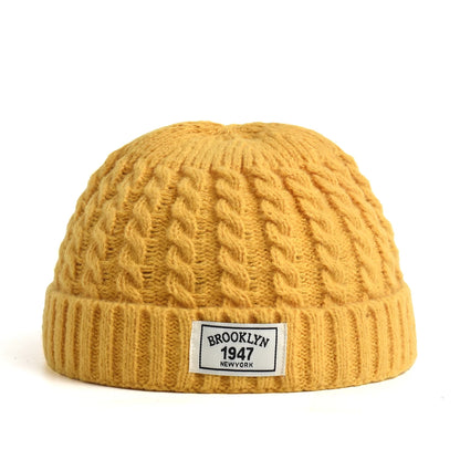 Brown Brooklyn knitted beanie cap for men and women, warm wool winter hat with simple, trendy skullie design for autumn and winter.