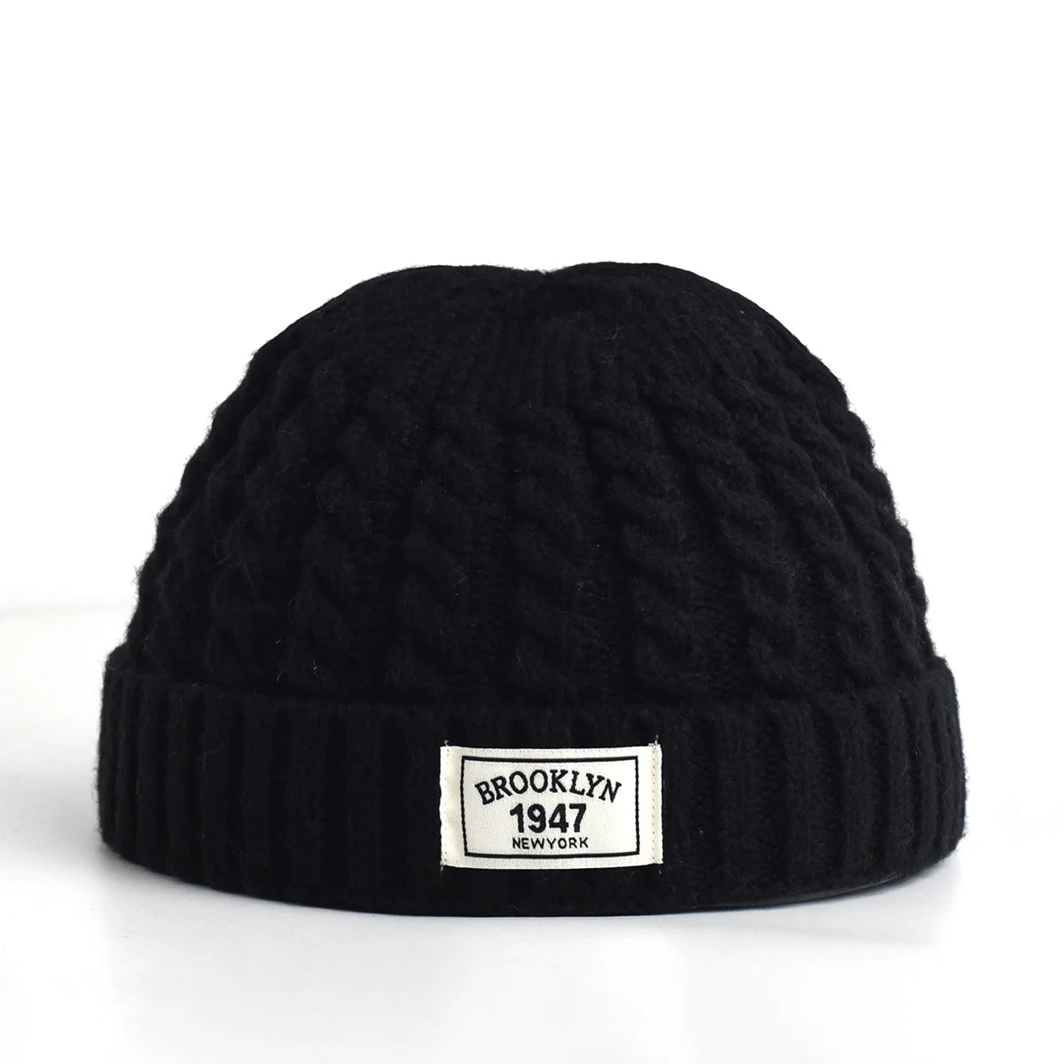 Brown Brooklyn knitted beanie cap for men and women, warm wool fashion skullie with simple, trendy style for autumn and winter.