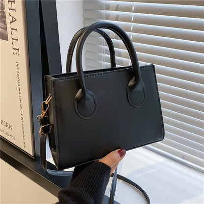 Elegant black handbag with dual handles and a chic crossbody strap, suitable for women and girls for daily use, work, or parties.
