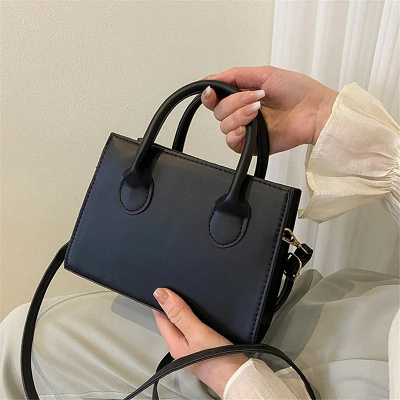 Elegant black handbag with dual handles and crossbody strap, stylish retro tote for women and girls, suitable for daily use or parties.