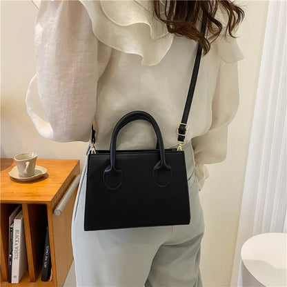 Elegant black handbag with dual handles and crossbody strap, stylish retro tote for women and girls, perfect for daily use and parties.