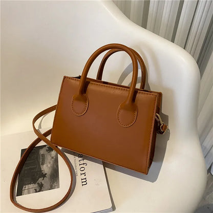 Elegant black handbag with dual handles and crossbody strap, stylish tote for women and girls, suitable for daily wear and parties.