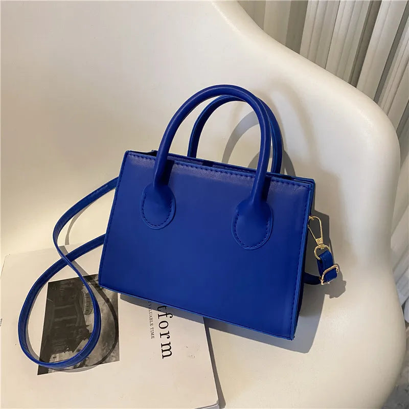 Elegant black handbag with dual handles and a crossbody strap, stylish tote for women and girls, suitable for daily use, work, and parties.