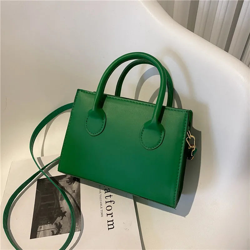 Elegant black handbag with dual handles and chic crossbody strap, featuring a retro stylish design for women and girls daily use.