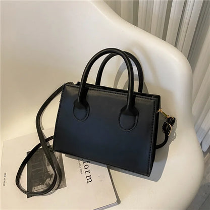 Elegant black handbag with dual handles and a chic crossbody strap, stylish tote for women and girls for daily use, work, or parties.