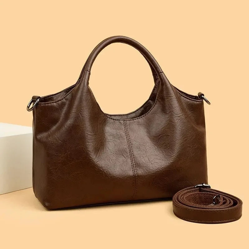 Large capacity women's PU leather handbag with zipper closure, shoulder strap, and multifunctional design in a fashionable coffee color.