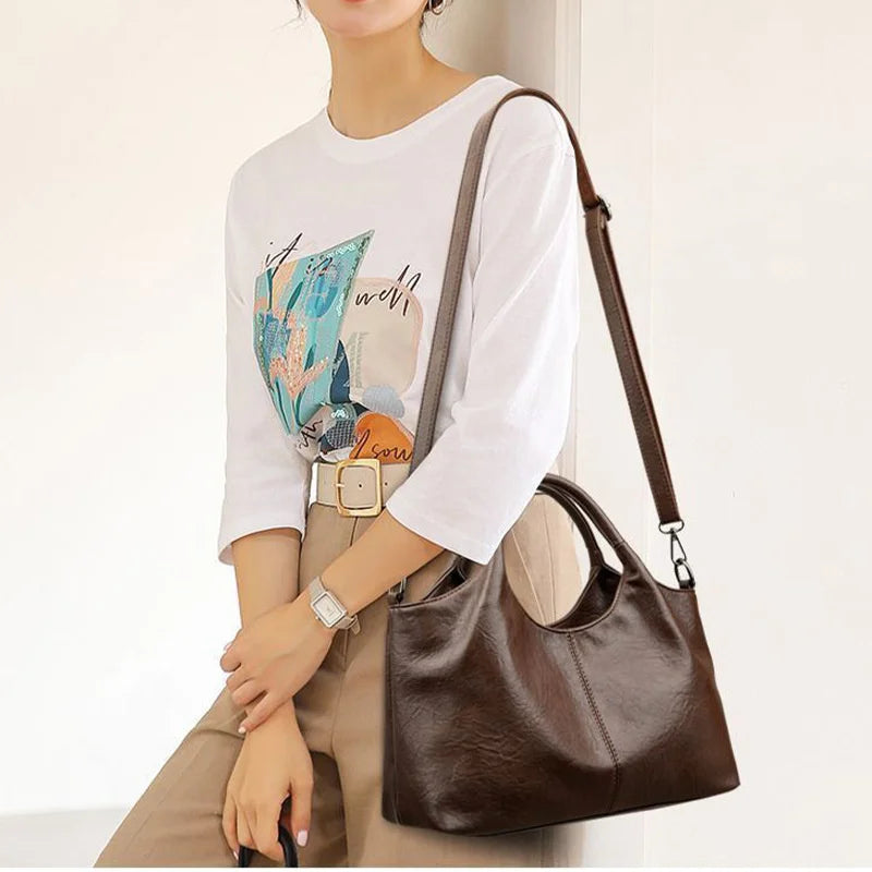 Fashionable large capacity women's PU leather handbag with shoulder strap, crossbody style, zipper closure, multifunctional design.