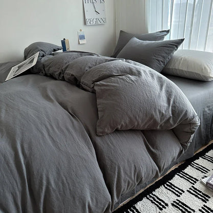 Dark blue solid cotton bedding set with duvet cover and pillowcases on a king-size bed, ideal for single, couple, or double beds.