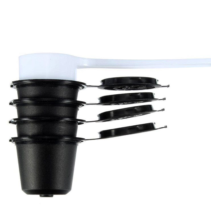 Set of four reusable coffee capsules with a coffee spoon, durable stainless steel, ideal for eco-friendly coffee brewing.