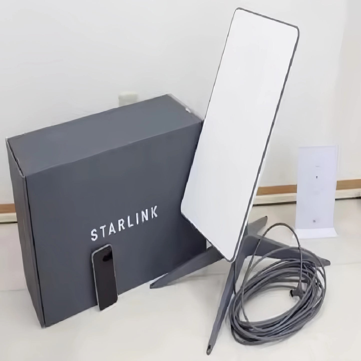 Starlink Standard Satellite Internet Kit V3 and V4 with satellite dish, router, and cables, set up outdoors for high-speed internet access
