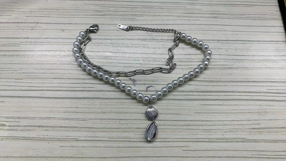 Stainless steel bohemian style personalized anklet with intricate design and adjustable chain on a neutral background.