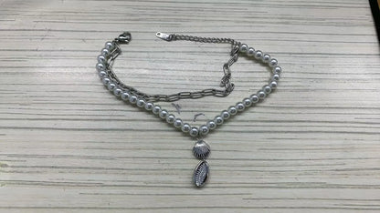 Stainless steel bohemian style personalized anklet with intricate design and adjustable chain on a neutral background.