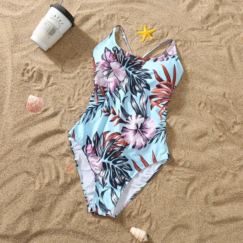 Matching floral pattern one-piece swimsuit for girl and swim shorts for boy, family beachwear with ruffle details for 2024.