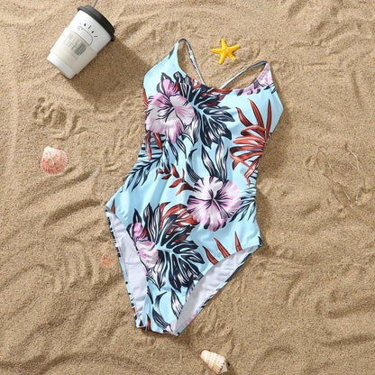 Matching floral pattern one-piece swimsuit for girl and swim shorts for boy, family beachwear with ruffle details for 2024.