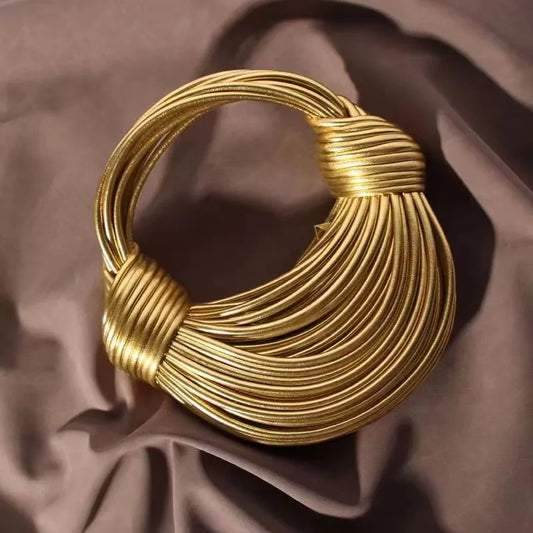 Luxury gold designer handbag for women, handwoven noodle bag with rope knots, silver evening clutch with chic, elegant design.