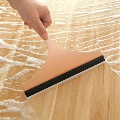 Green silicone glass scraper and wiper for car mirrors, shower, and window cleaning, with brush holder for kitchen and bathroom use.