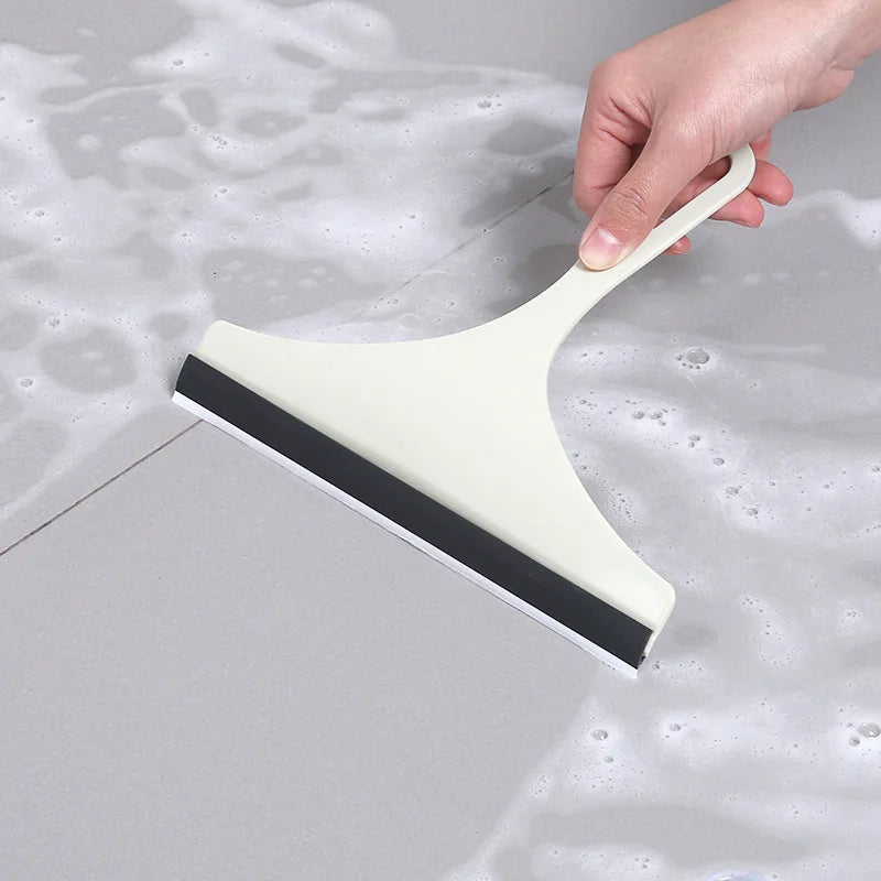 Green silicone glass scraper and squeegee for car mirrors, shower, and window cleaning, with brush holder for kitchen and bathroom.