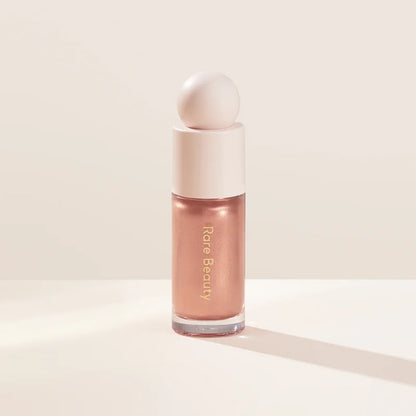 Rare Beauty liquid blush cream with dewy finish, blendable multi-use cheek and lip tint in a portable makeup container.
