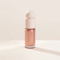 Rare Beauty liquid blush cream with dewy finish, blendable multi-use cheek and lip tint in a portable makeup container.