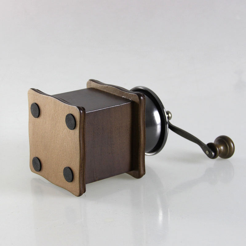 Manual coffee grinder from BACKUPMYFILESNOW.COM® with a compact design ideal for home use, featuring a ceramic burr and hand crank.