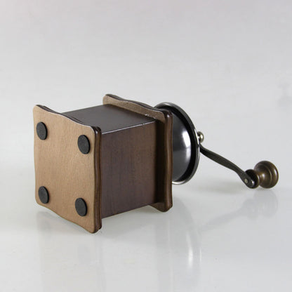 Manual coffee grinder from BACKUPMYFILESNOW.COM® with a compact design ideal for home use, featuring a ceramic burr and hand crank.