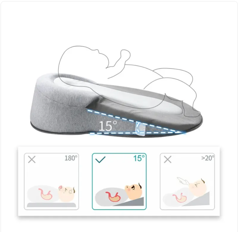 Light grey baby anti-spit up pillow with safety strap, designed to keep infants comfortable and reduce spit-up incidents.