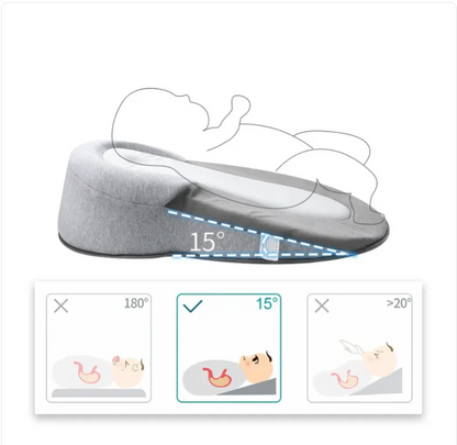 Light grey baby anti-spit up pillow with safety strap, designed to keep infants comfortable and reduce spit-up incidents.