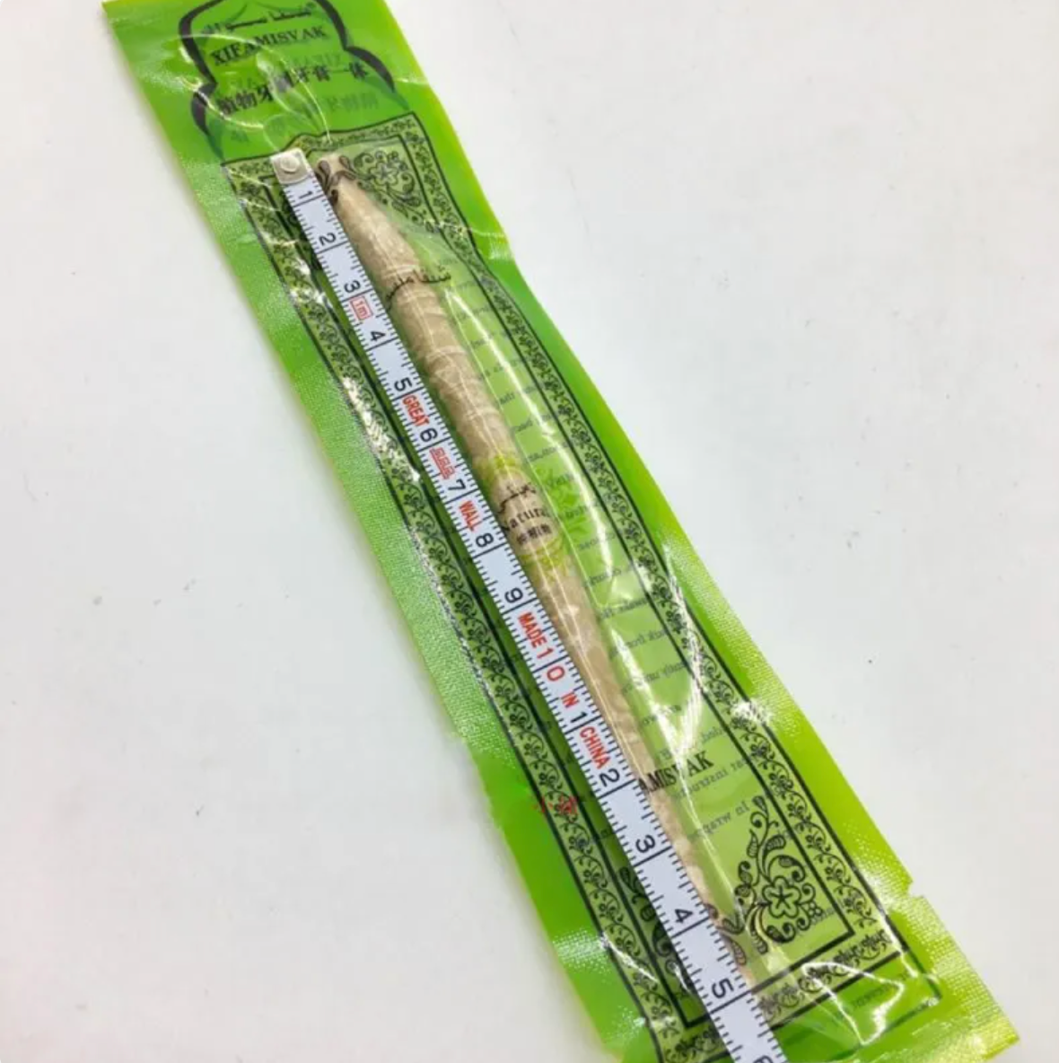 Natural Miswak tooth cleaning stick from BackupMyFilesNow.com with a wooden handle and bristles for oral hygiene.