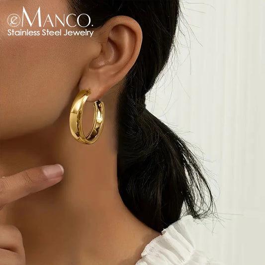 Silver stainless steel round hoop earrings by eManco featuring geometric circle design for men and women, stylish huggie jewelry.