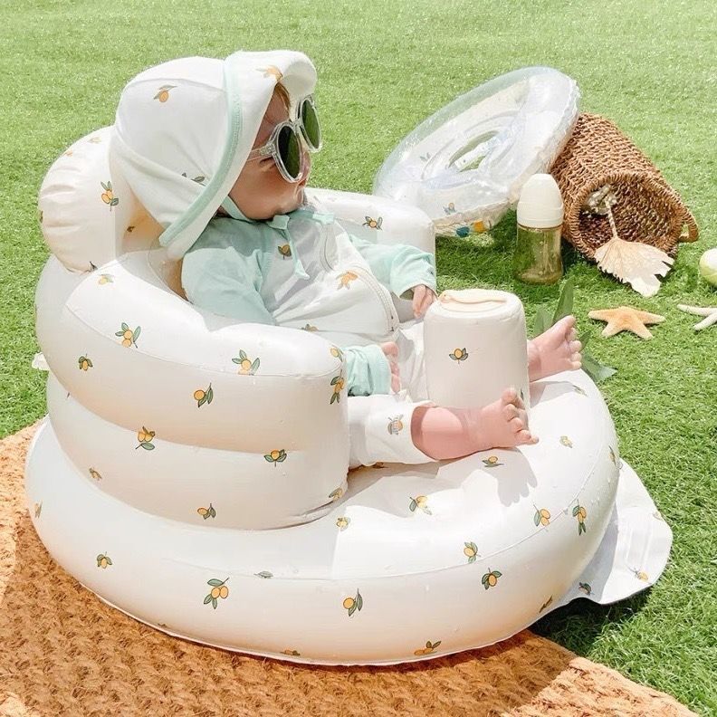 Inflatable rainbow baby chair for dining and bath, designed for infants, with colorful rainbow pattern and soft, secure seating.