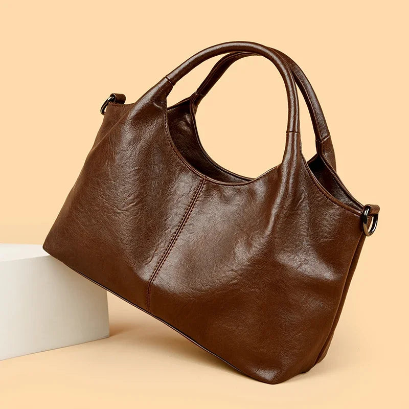 Red leather women's tote bag with soft, large capacity, shoulder strap, and crossbody style, featuring designer craftsmanship.