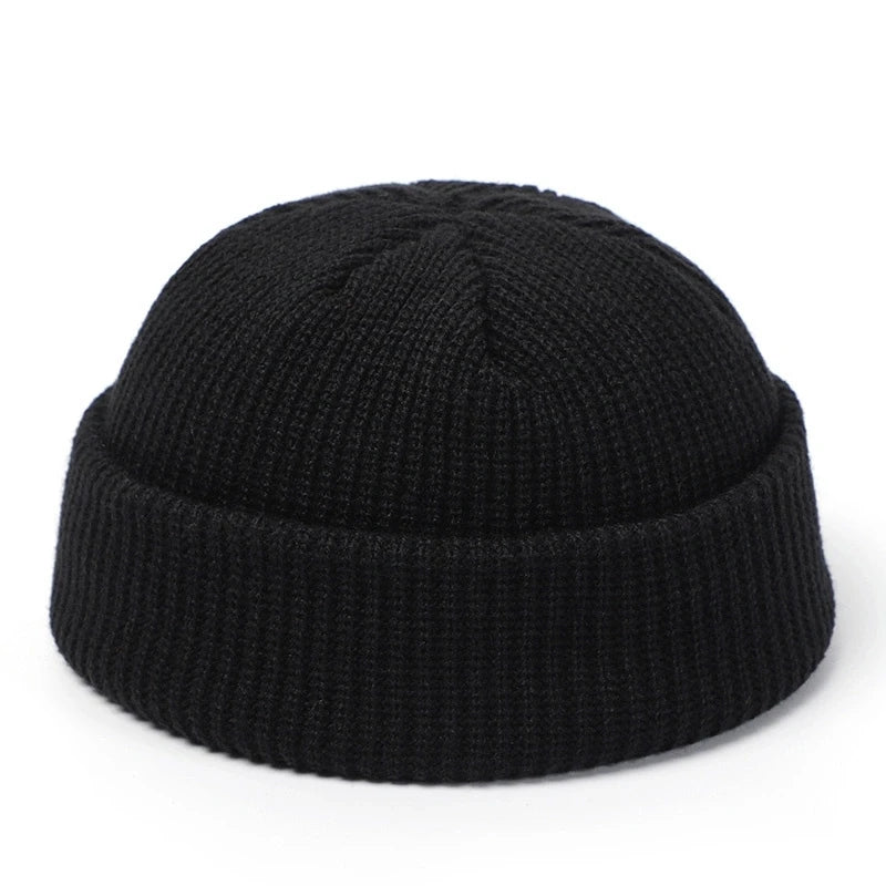 Red knitted beanie cap for men and women, warm woolen skullie hat with simple, solid design for autumn and winter fashion.